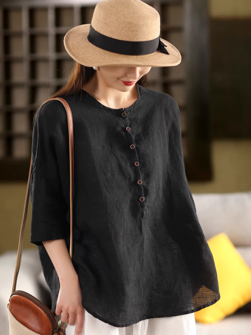 A woman wearing a Black solid color shirt top with a classic crew collar
