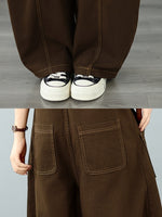 A person wearing loose brown wide-leg pants. 